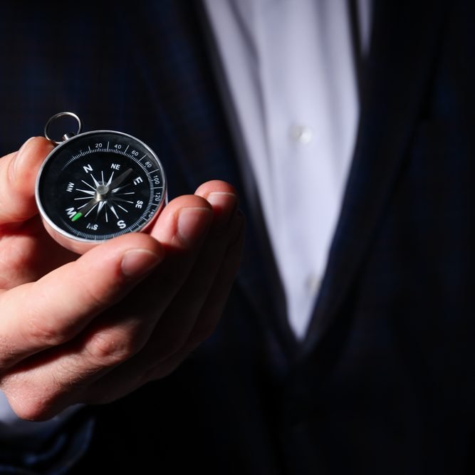 Business navigate concept with compass in businessman hand